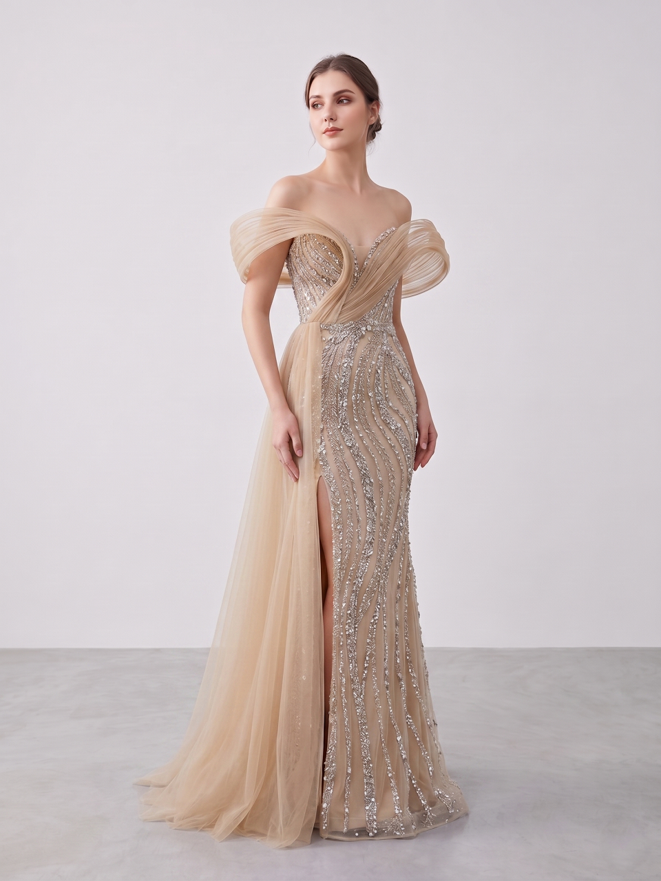 Champagne crystal beaded mermaid evening dress with sculptural off shoulder tulle sleeves and flowing overskirt train